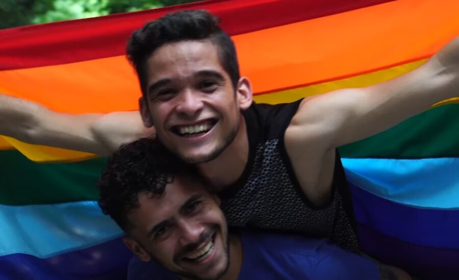 Two happy guys holding LGBT flag