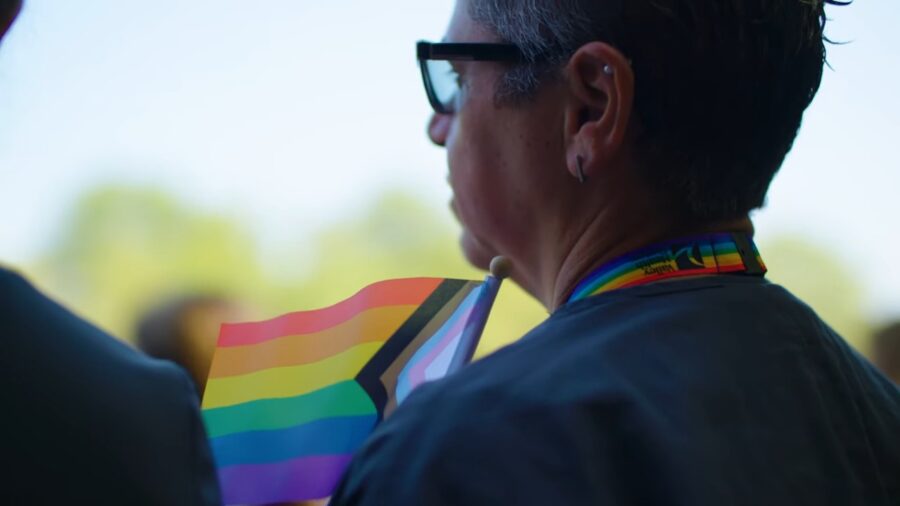 Older woman holds pride flag