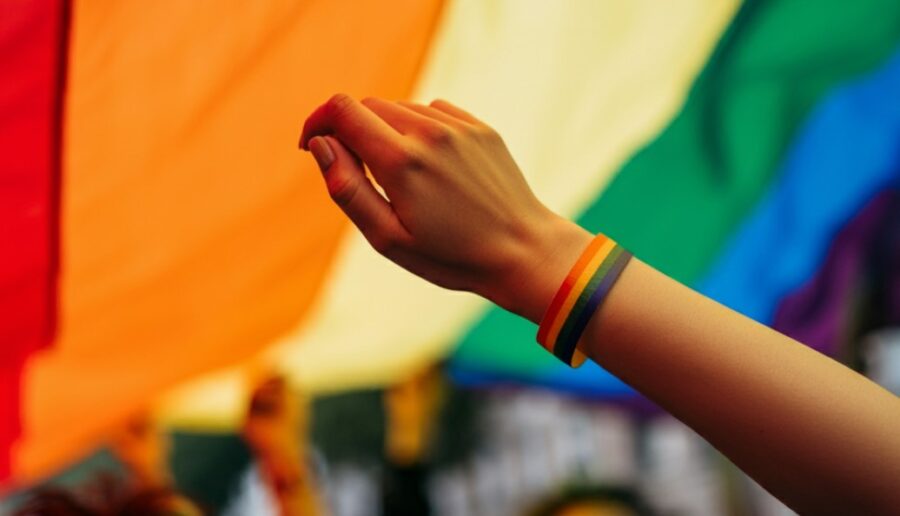 Close up of an LGBT armband with LGBT flag in the background