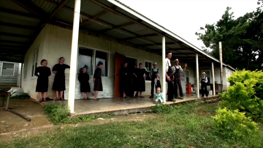 A Mennonite Family, Dressed in Traditional Plain Clothing, Stands Together Outdoors