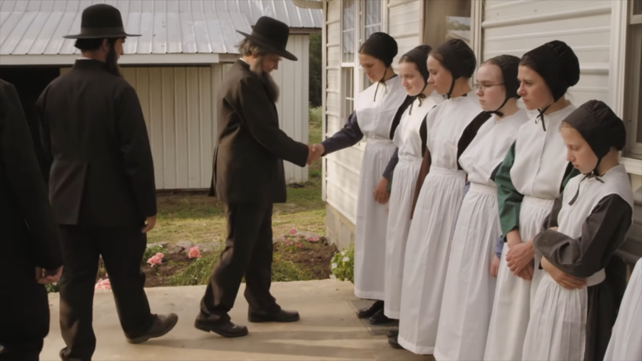 Amish Men and Women, Dressed in Traditional Plain Clothing, Stand in Line as Part of A Religious Service