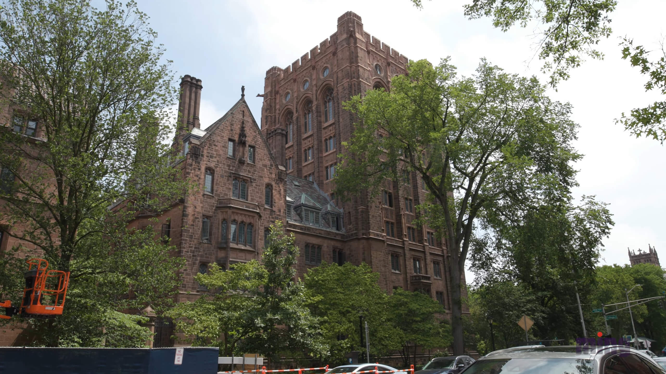 A view of Yale University showcasing its historic Gothic-style architecture surrounded by lush green trees