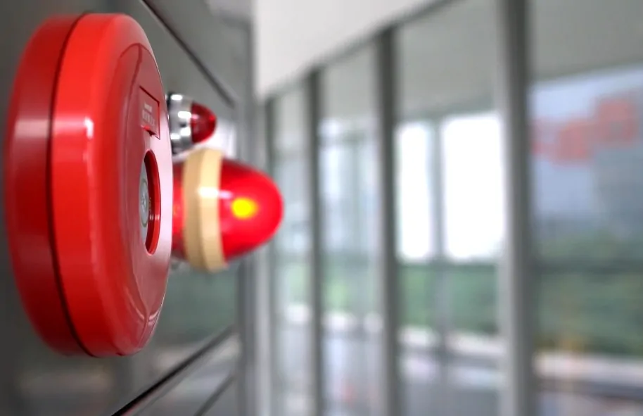 A red fire alarm siren on a wall