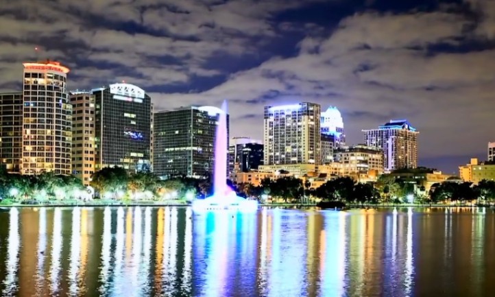 Orlando skyline illuminated at night, showcasing tall buildings and vibrant city lights