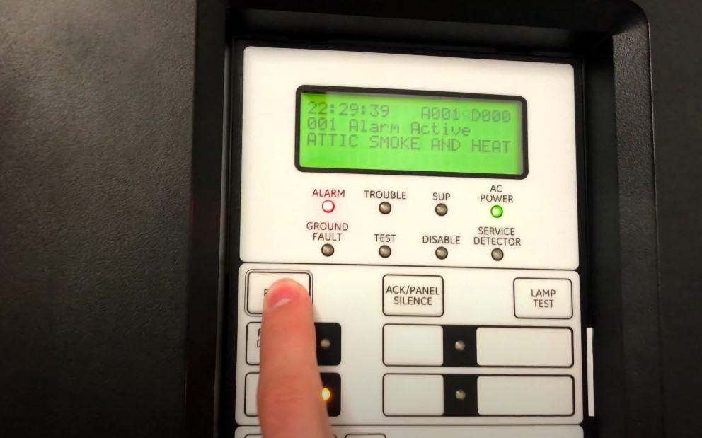 A person is touching alarm's control panel with a finger