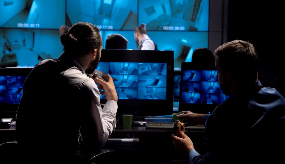 Two security workers watching surveillance camera