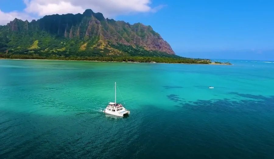 Boat on a water with mountains in the back