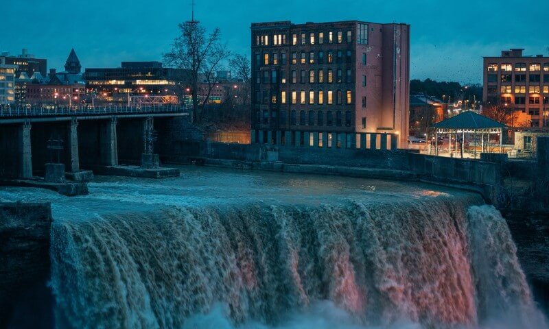 Dusk settles over the roaring industrial waterfall in Rochester