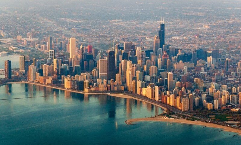 Aerial view of a vibrant Chicago skyline with tall skyscrapers reflecting in a lake