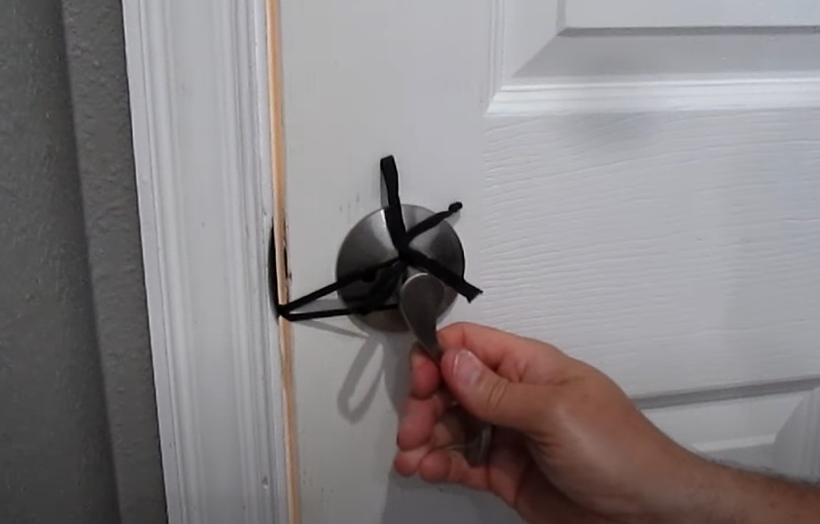 Guy locks house door using shoelace