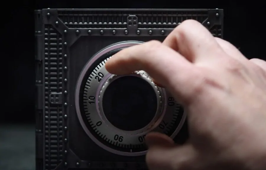 A hand opens a locked safe