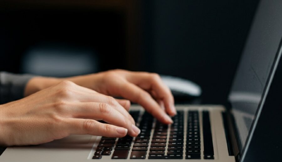 Close up photo of hands typing on keyboard