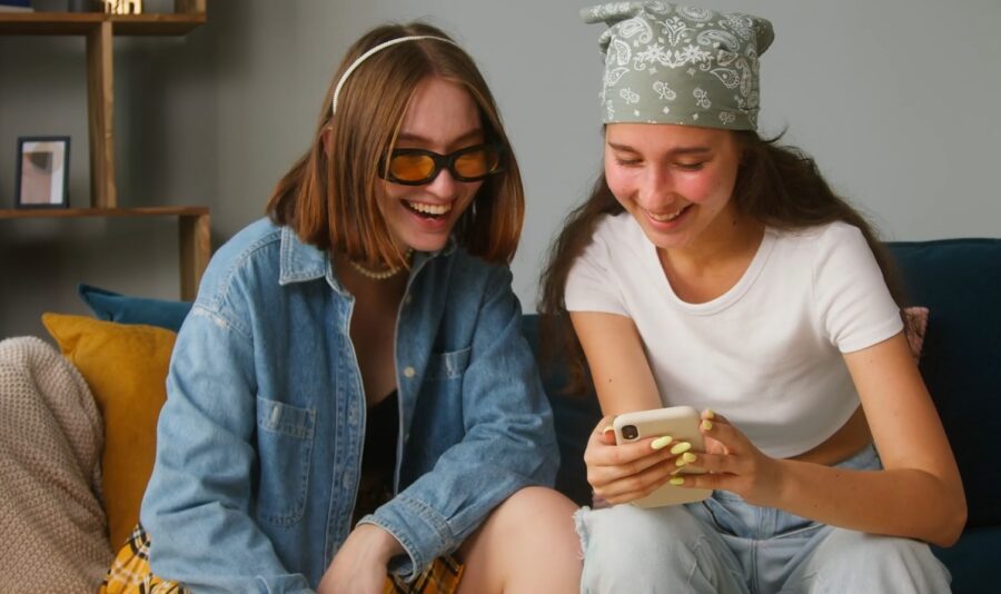 Two roommates laughing while watching phone