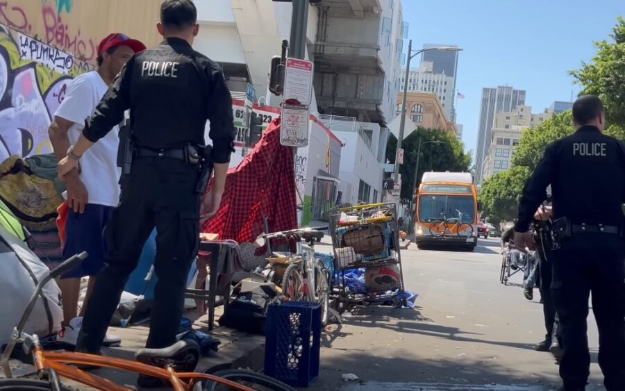 Police arresting homeless guy on the street