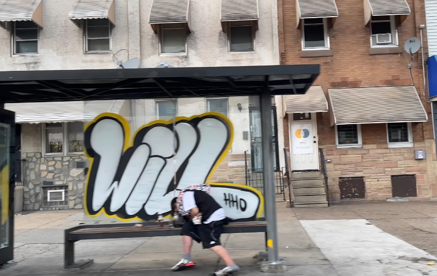 Homeless guy sleeping on a bus stop