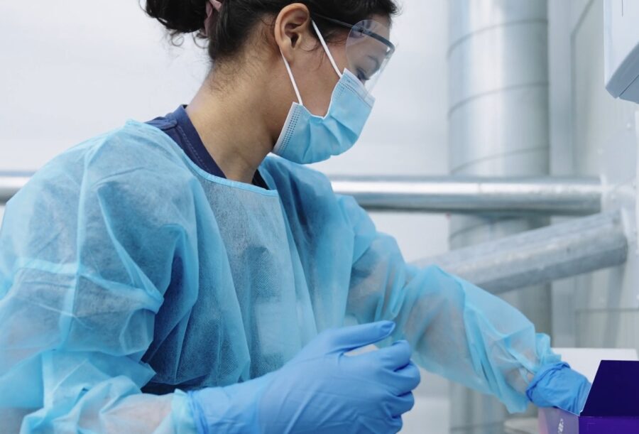 Medical worker putting gloves in a workplace