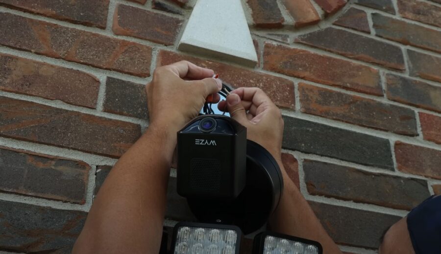 Professional installing security camera on a house