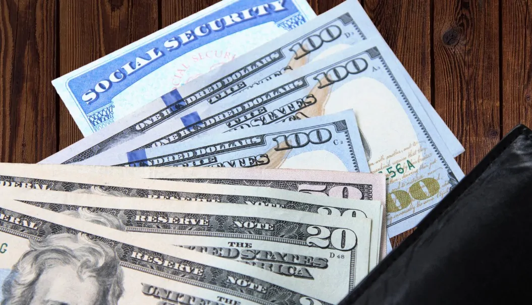 Social security card and dollar bills on a table