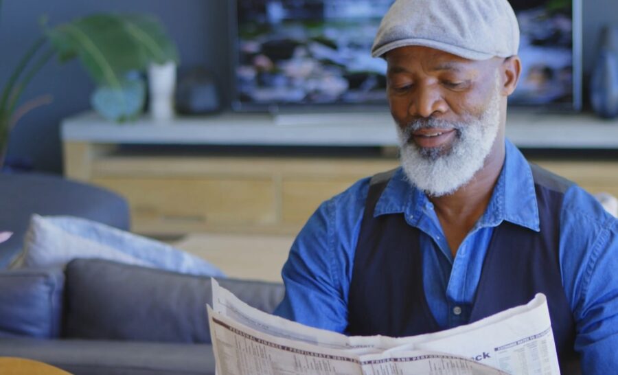 Relaxed senior reads the day's newspapers