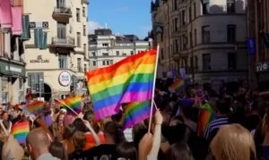 A vibrant Pride parade fills the city streets