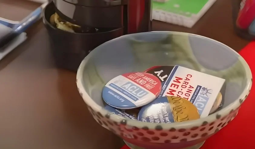 A collection of advocacy buttons and cards, nestled in a speckled bowl