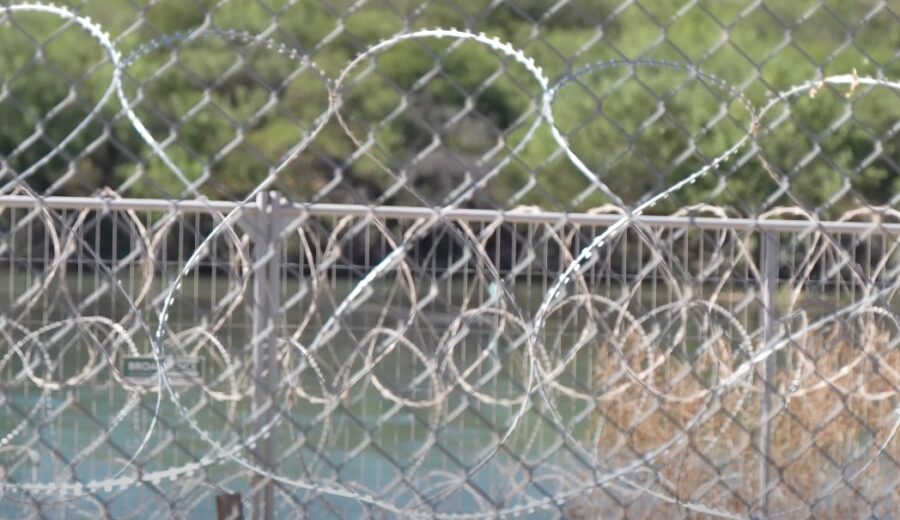 A chain-link fence topped with razor wire