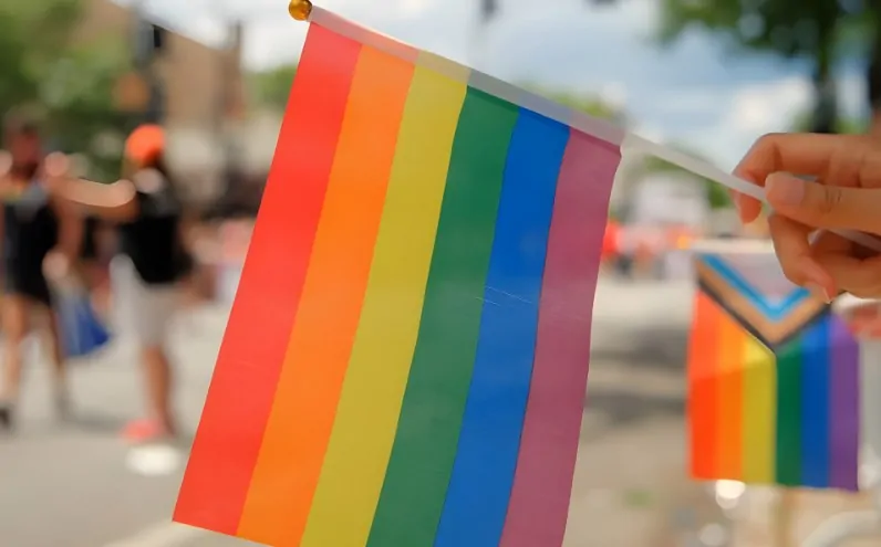 A vibrant rainbow flag, a symbol of pride and unity, waves in the breeze