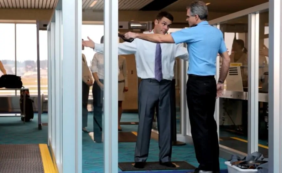 Security checkpoint, a man in a suit, being scanned