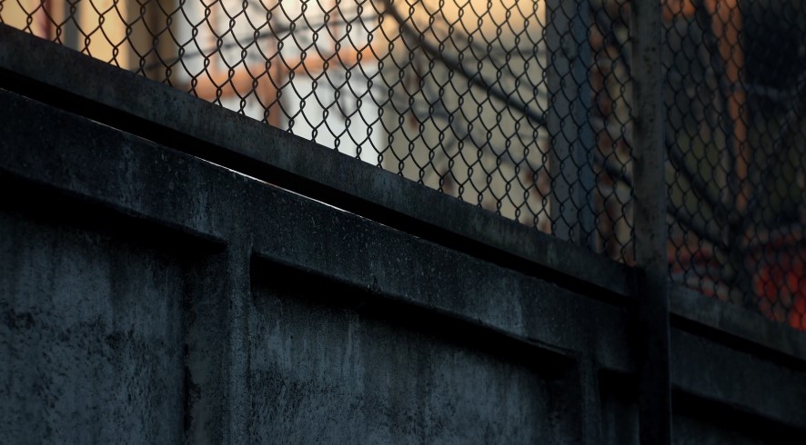 Close-up view of a dark, aged metal fence