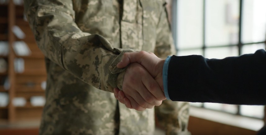 A firm handshake between a soldier and a civilian