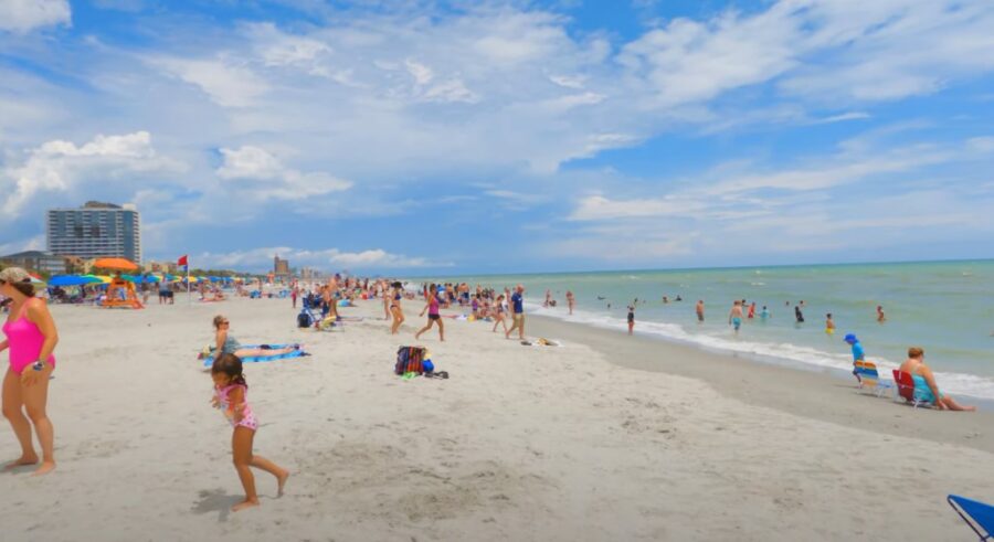  A bustling beach scene filled with people enjoying the sun