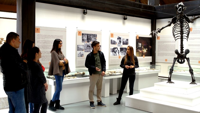 A group of people are engaged in a guided tour of a museum exhibit