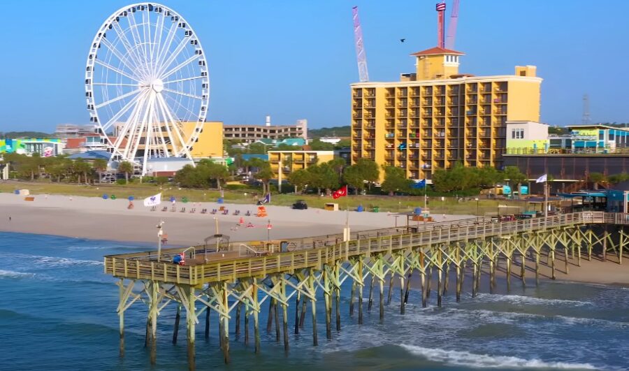 Sunny beachfront scene with a vibrant Ferris wheel and a charming pier