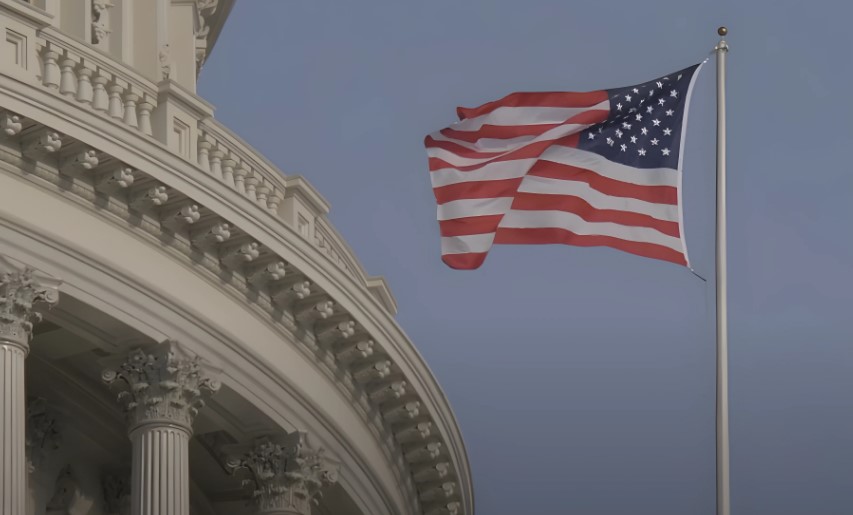 The American flag, a symbol of freedom, waves proudly above the Capitol building