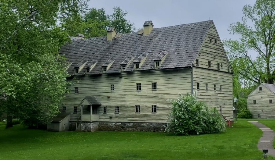 Old Amish barn, lush green grass, and blossoming trees