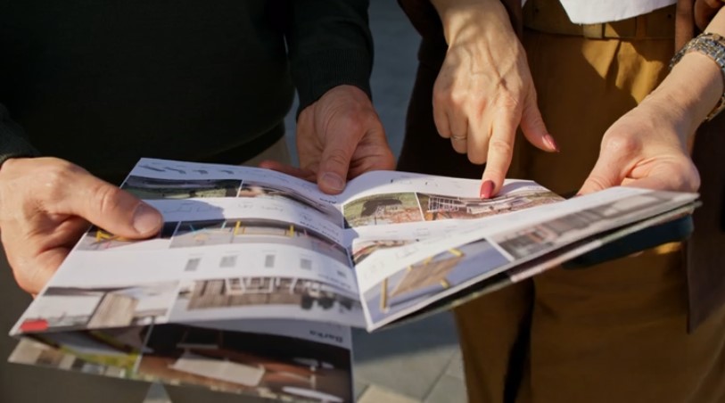 Potential clients looking at the real estate brochure
