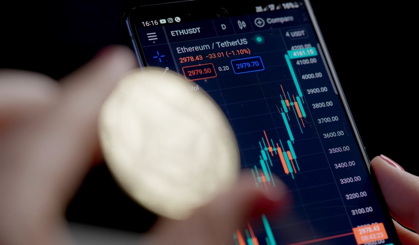 A mobile phone displays real-time cryptocurrency trading data