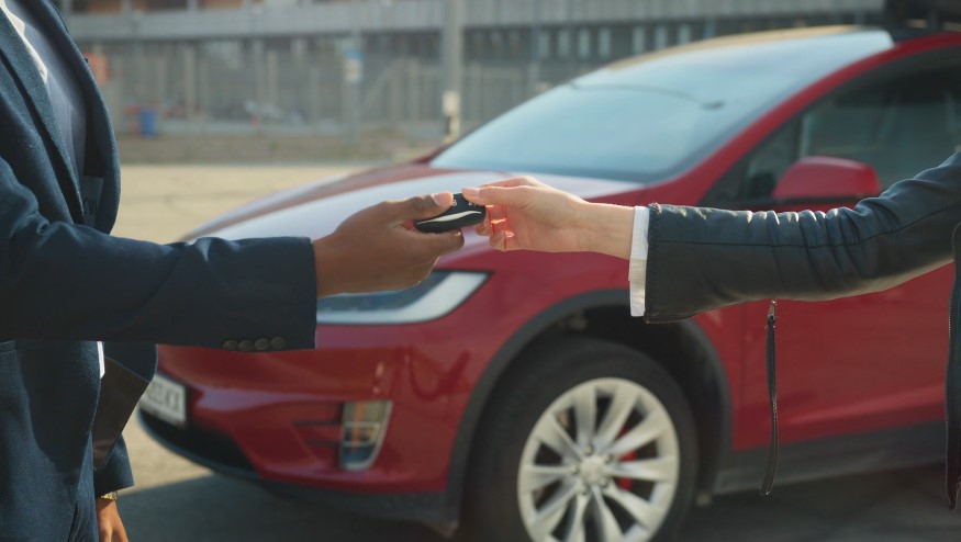 Hands exchange a car key