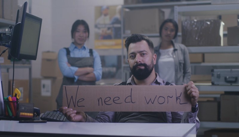 A cardboard sign conveys the need for more work