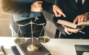 Two lawyers review legal documents next to a scale of justice, representing major personal injury settlements in U.S. history