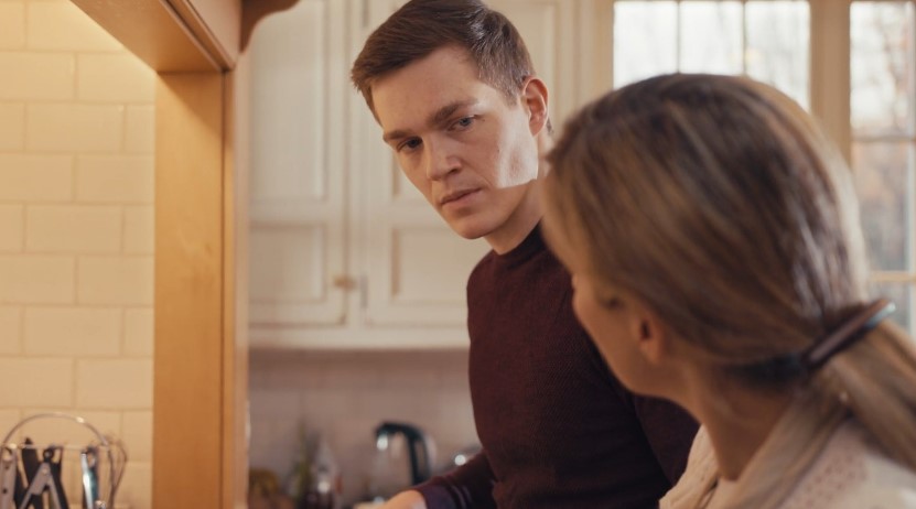 Two individuals engaged in a conversation within a kitchen setting