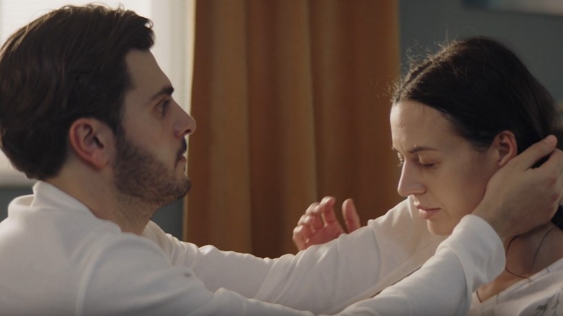 The man gently holds the woman, offering solace