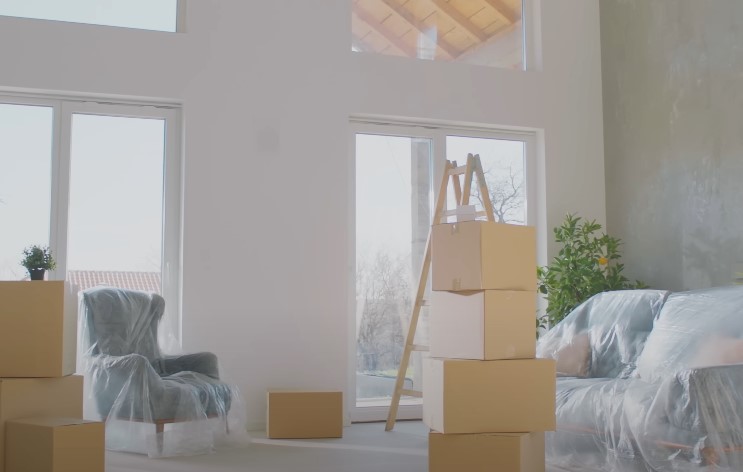 A cluttered room filled with various boxes and pieces of furniture scattered throughout the space