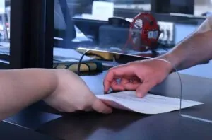 Documents being exchanged across a protective barrier