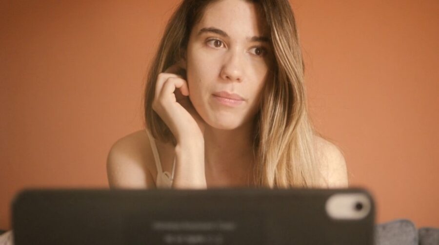 Worried woman reporting online crime using her laptop