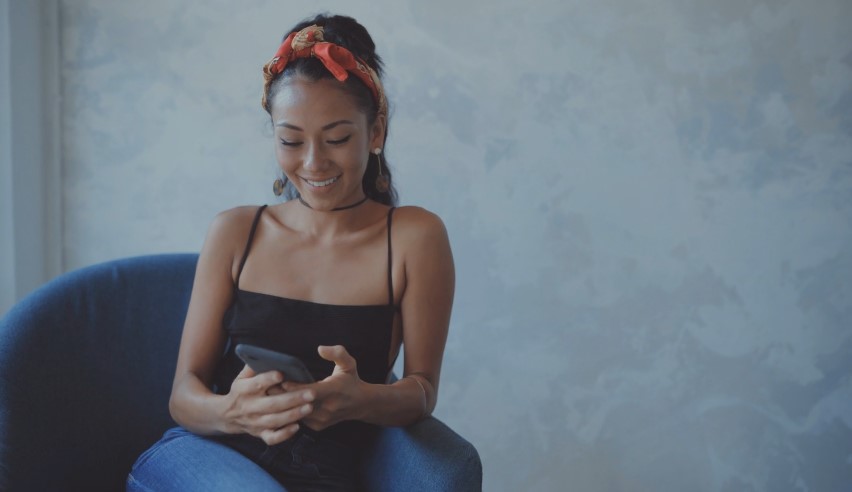 Woman smiling while looking at her phone