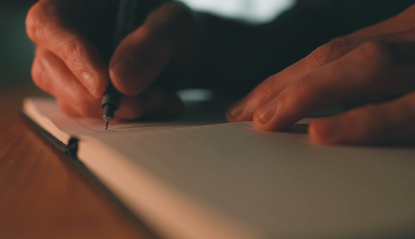 A person writing a journal, close up view