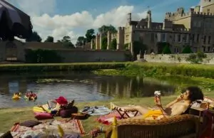 A scene from the Saltburn movie, picnic by the lake, featuring colorful textiles and comfortable seating
