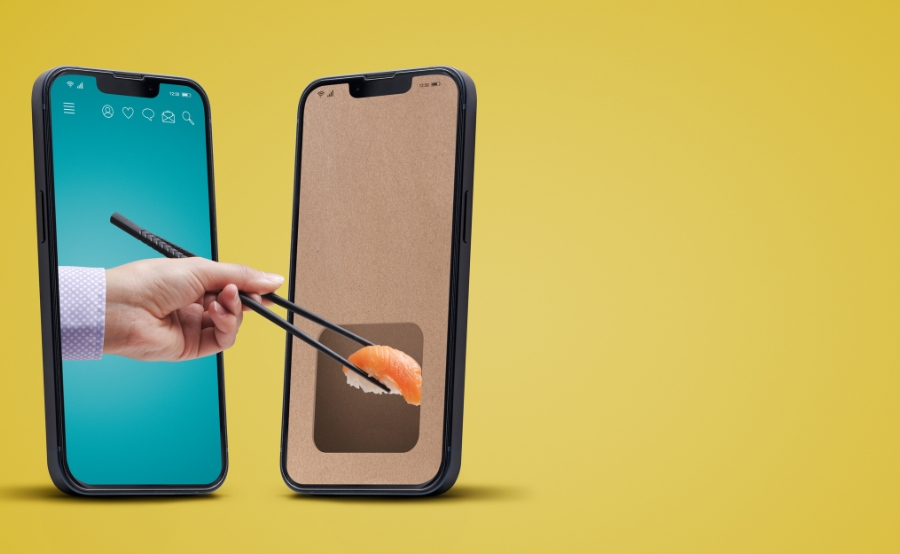 A hand grabs sushi through a phone screen, showing how food apps grew before Boston’s delivery crackdown