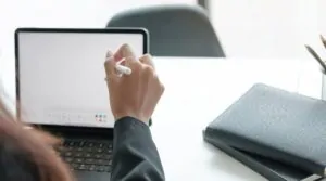 A person uses a stylus on a tablet at a desk, symbolizing digital tools that support human rights campaigns